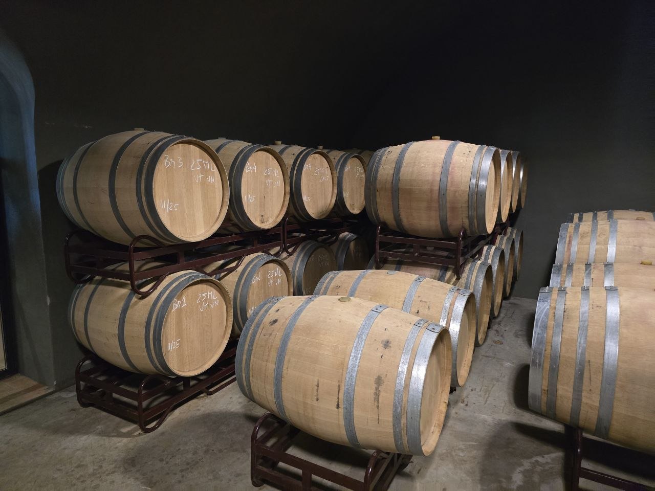 Stacked wine barrels in a dark Cabrita Wines cellar room