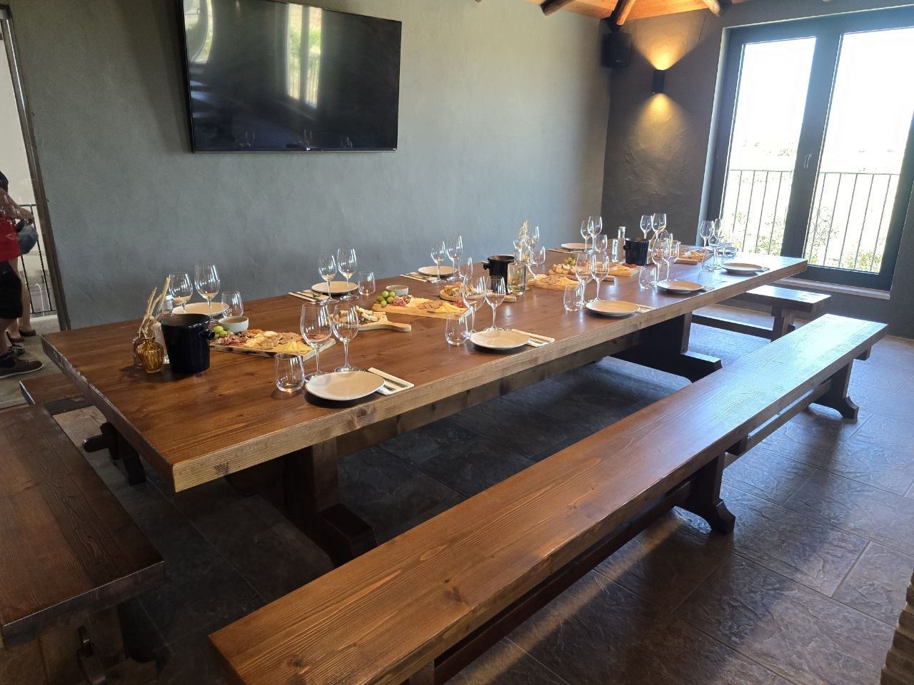 Long wooden tasting table set with wine glasses and charcuterie boards at Cabrita Wines