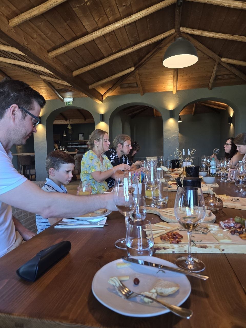 Cabrita Wines tasting table with wine glasses, charcuterie, bread, and guests