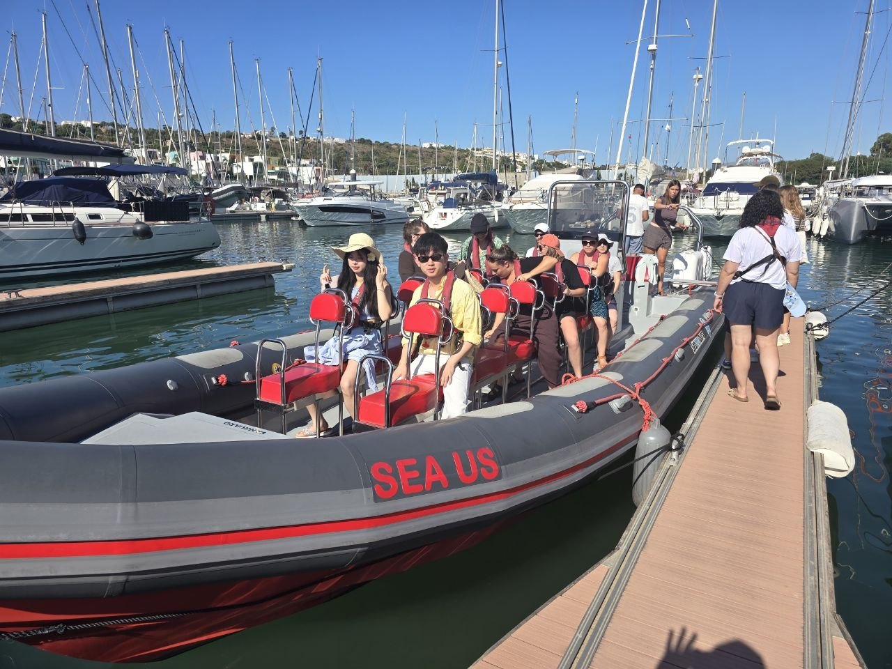 Passengers boarding a grey zodiac boat at the Albufeira marina