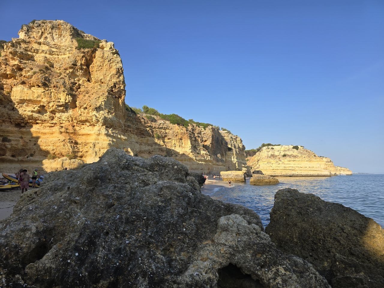 Golden Praia da Marinha cliffs and large shoreline rocks above blue water