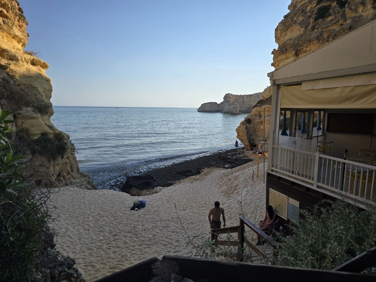 Seaweed-covered shoreline at Praia da Marinha below the beach restaurant and stairs