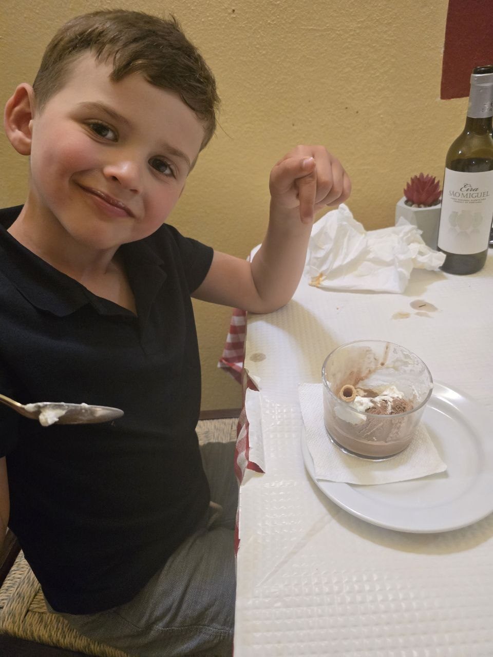 Noah smiling beside his finished chocolate dessert at La Vera