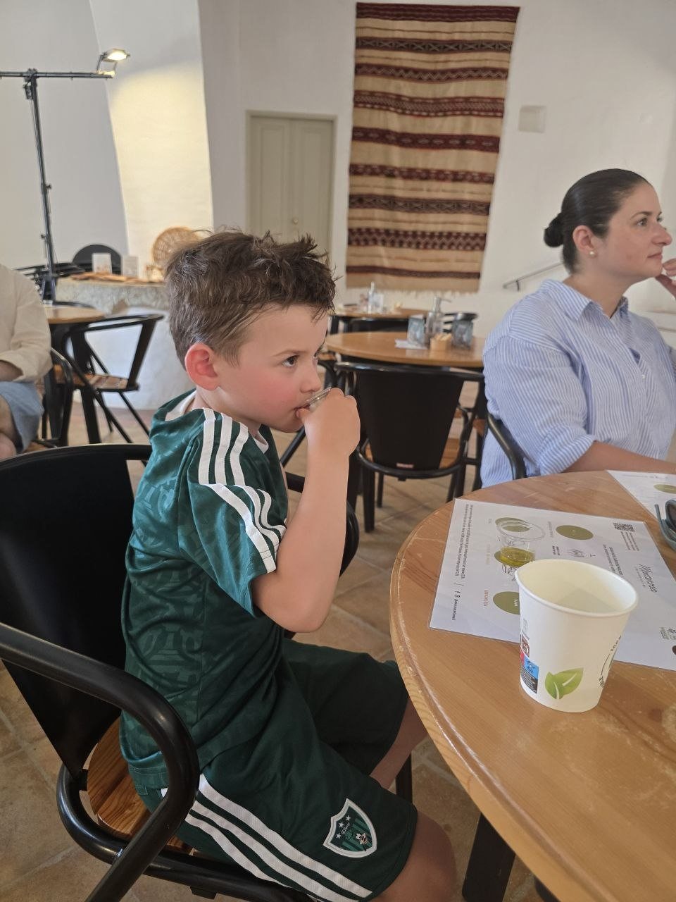 Noah smelling a small glass of olive oil during the Monterosa tasting