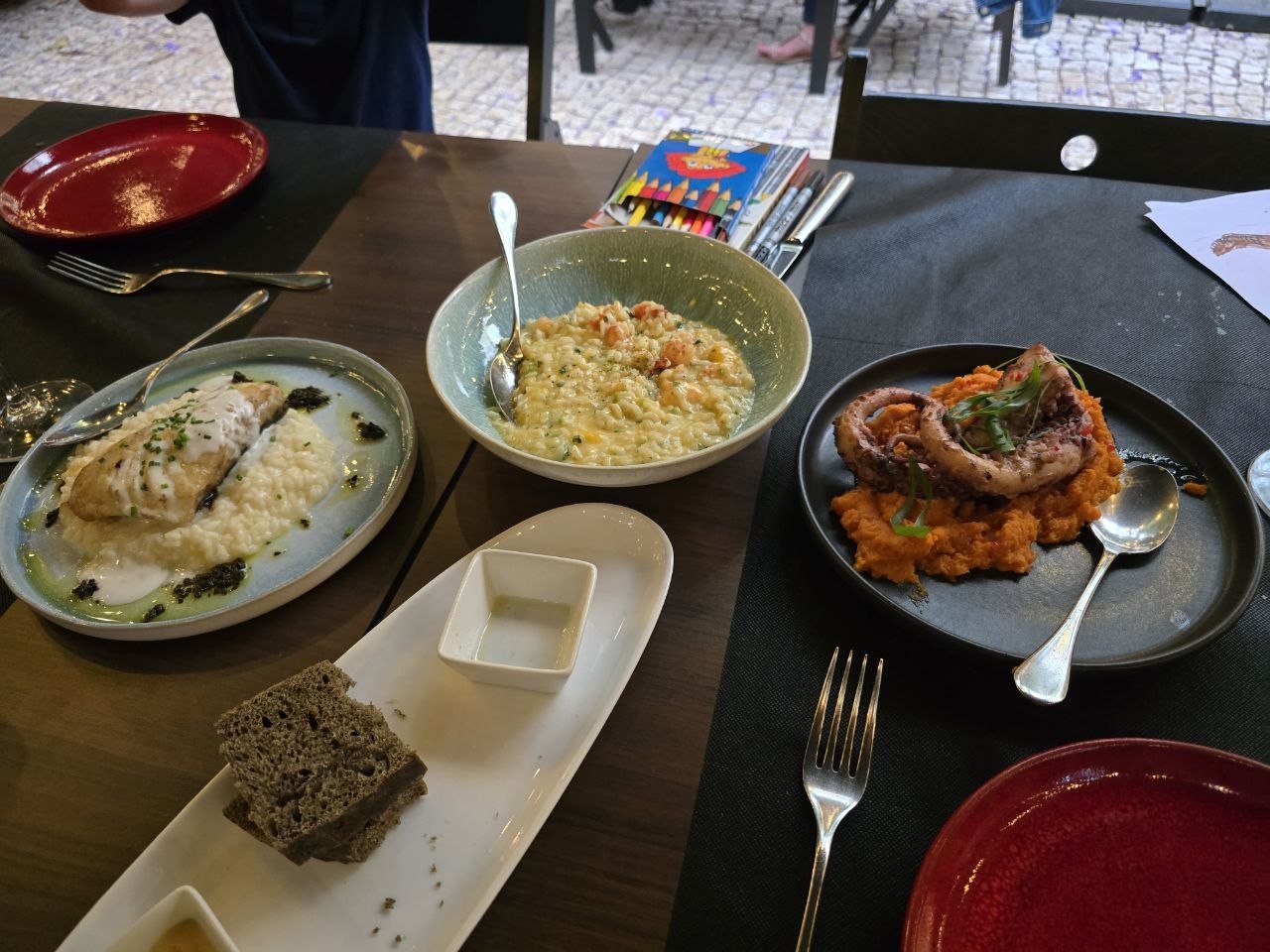 Shared dinner dishes at Clube de Jornalistas including fish, risotto, octopus, bread, and olive oil