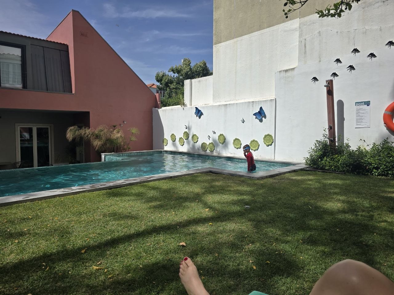 Noah swimming in the Jardim da Lapa pool beside a wall decorated with butterflies