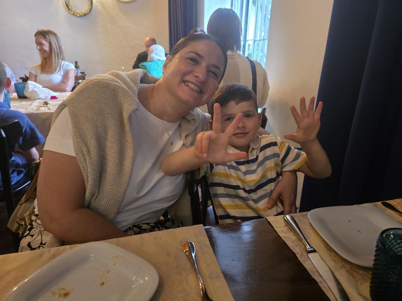 Catherine and Noah smiling together at the Come Prima restaurant table