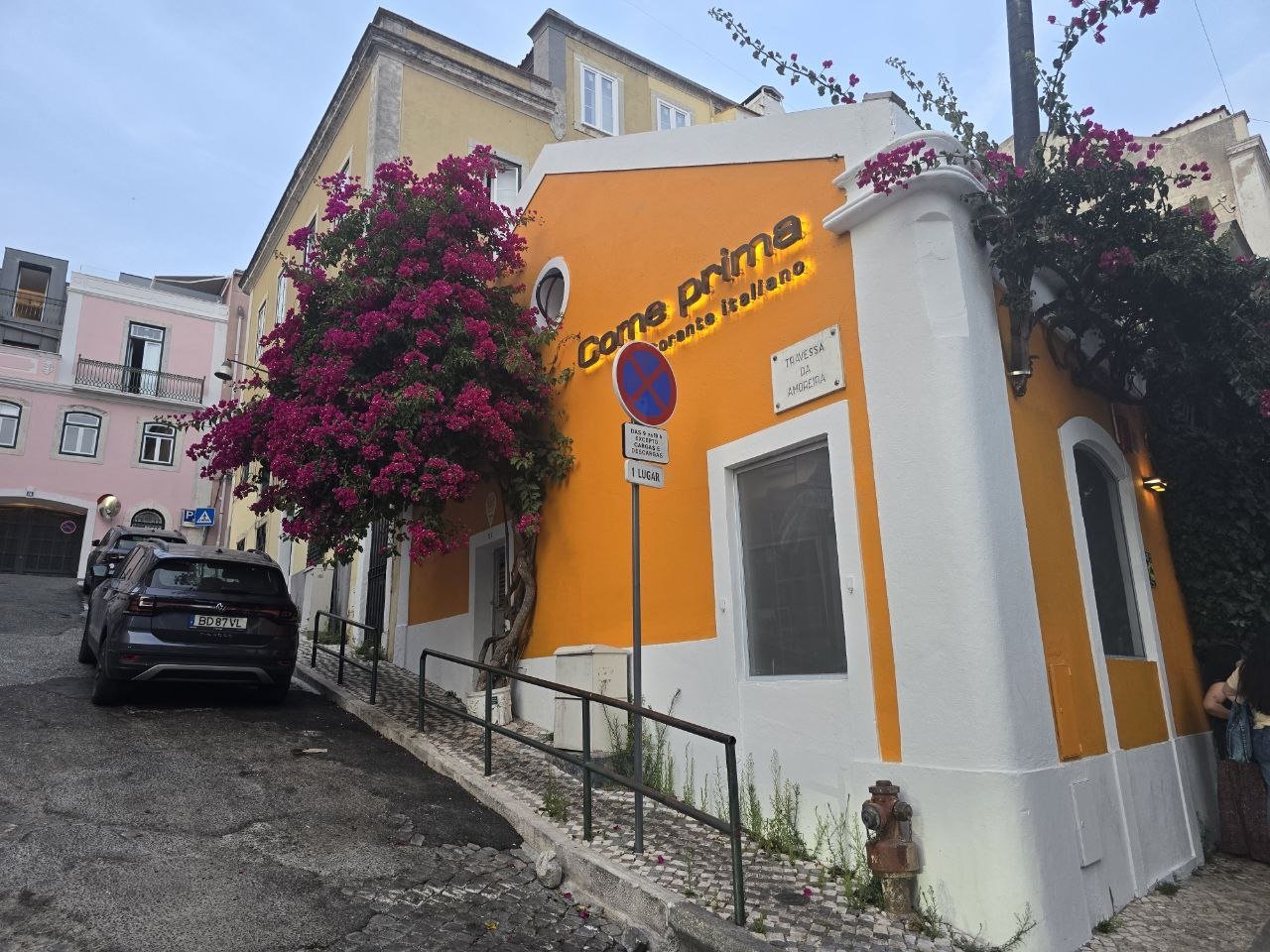 Orange Come Prima Italian restaurant exterior with bougainvillea in Lisbon