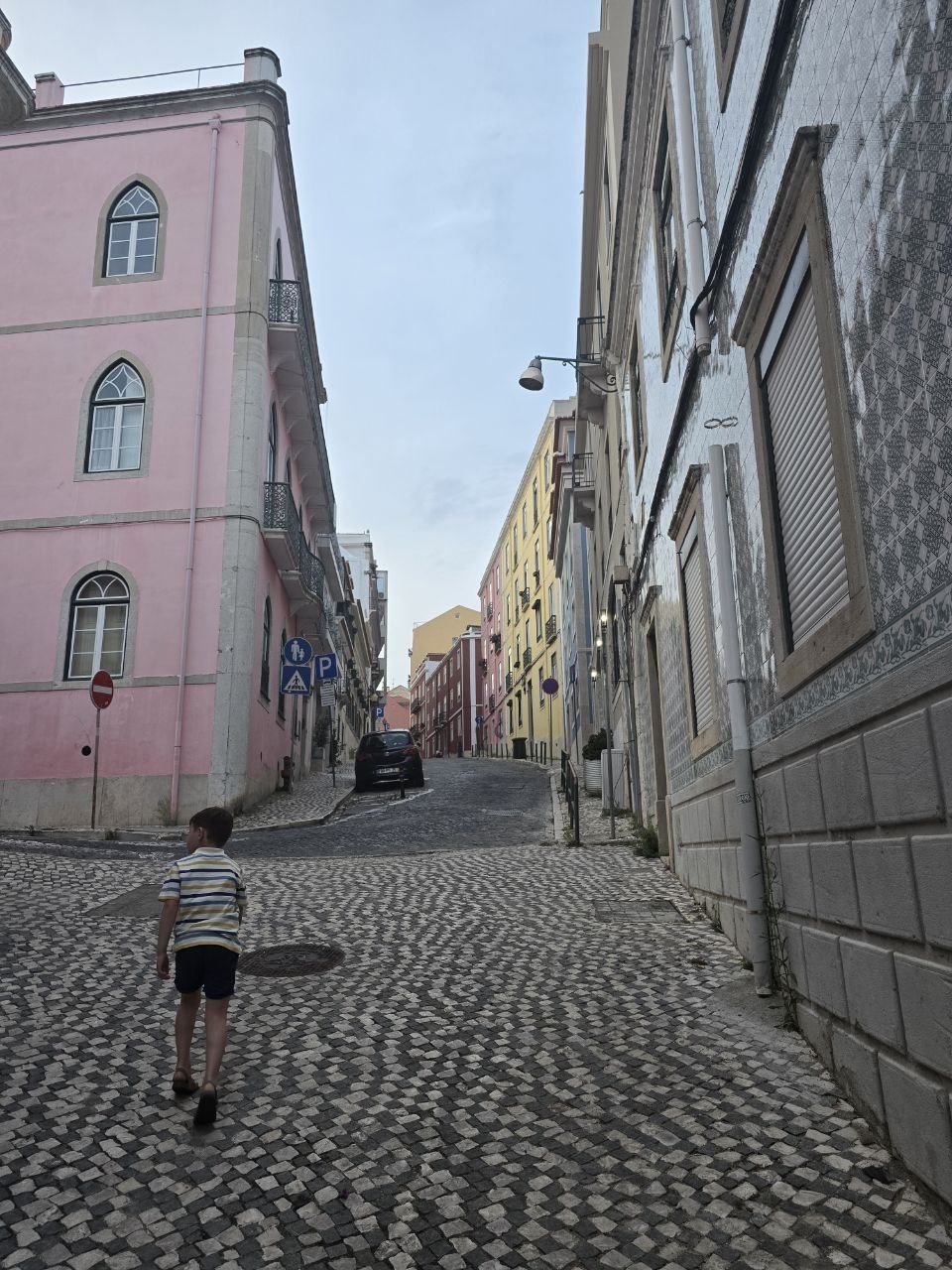 Noah walking uphill through colourful Lisbon streets after dinner