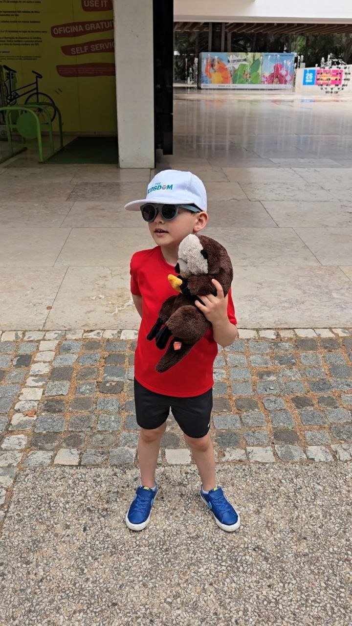 Noah holding Otto Renaud the otter plush outside the Oceanário