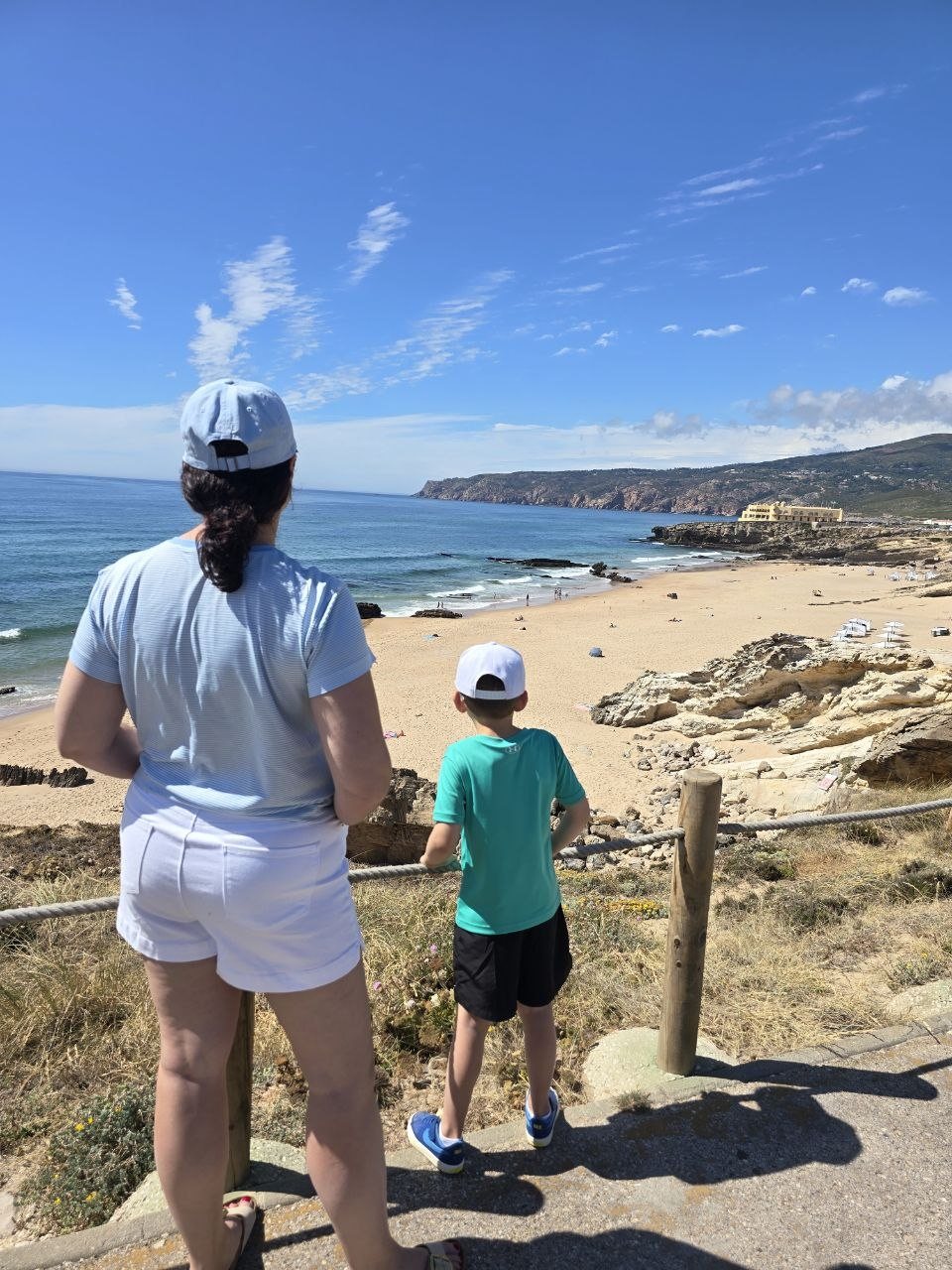 Dad and Noah looking out over a beach from a coastal viewpoint