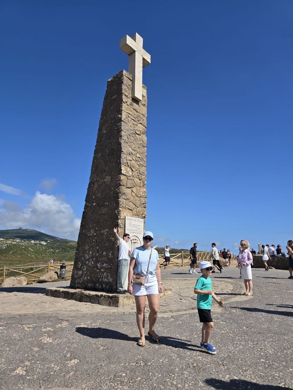 Noah and Dad at a tall stone cross viewpoint overlooking the coast