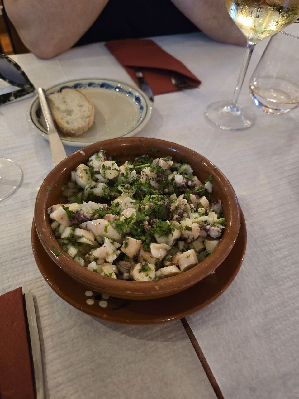 Octopus salad in a clay bowl at Restaurant Pereira