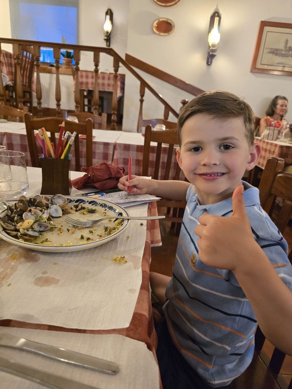 Noah giving a thumbs-up beside empty clam shells at Restaurant Pereira