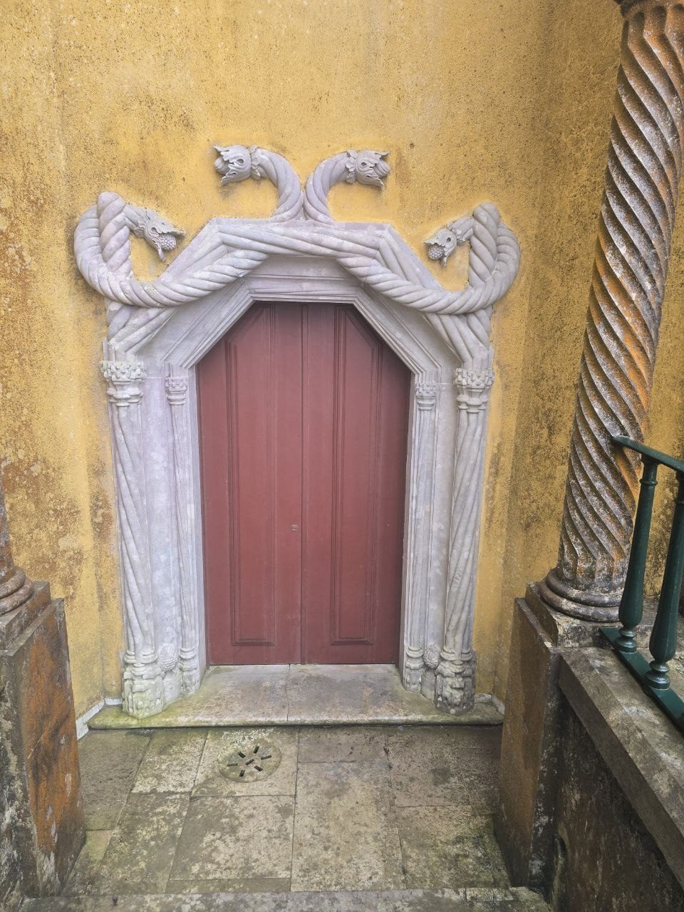 Small red decorative door in yellow palace wall