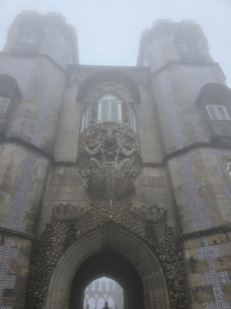 Stone Pena Palace entrance and window details in heavy fog