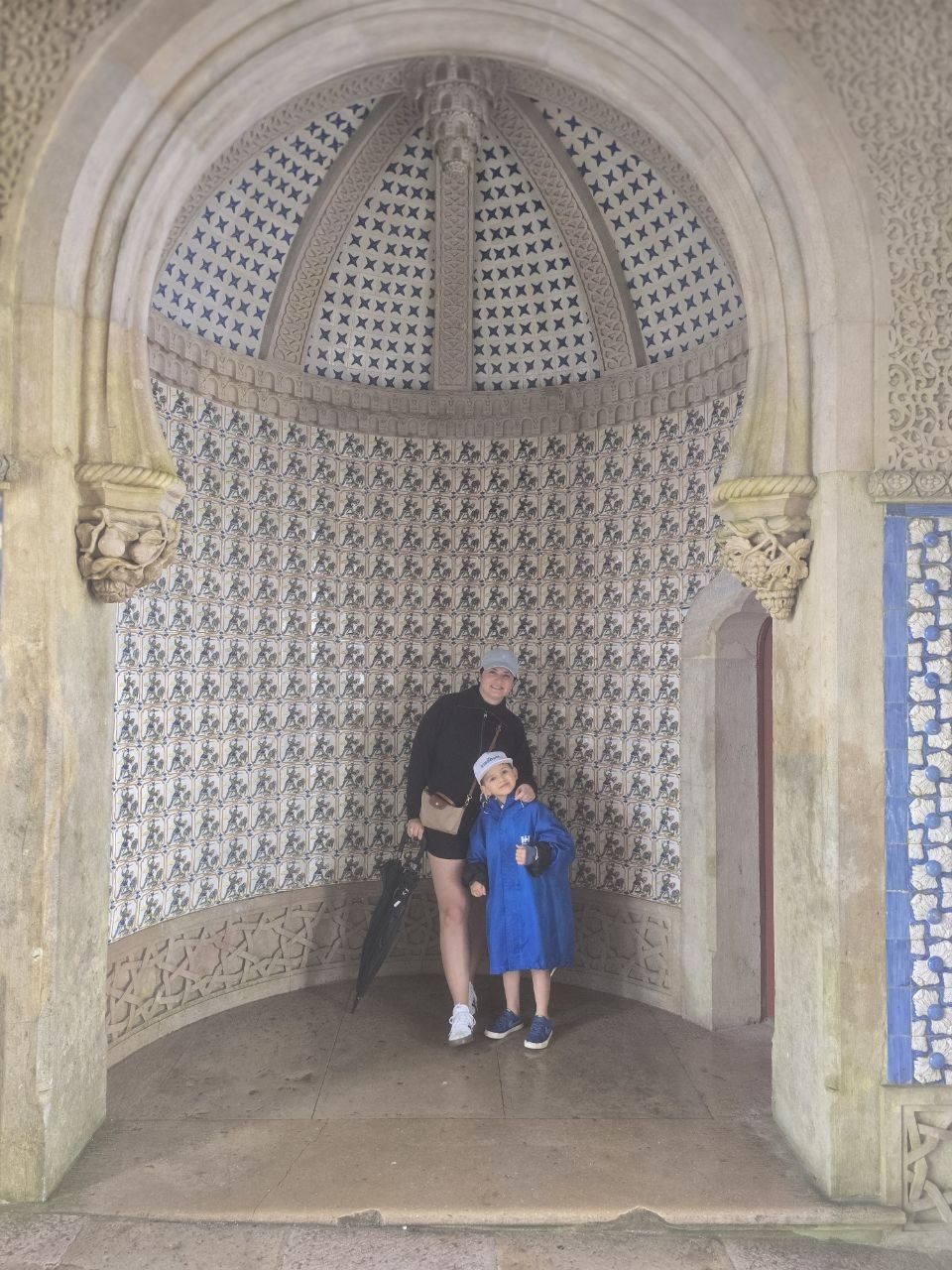Noah standing in an arched alcove lined with blue and white tile