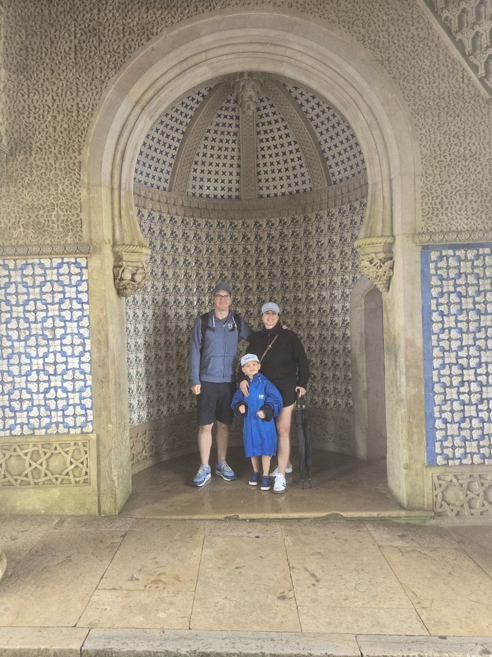 Family standing together in a tiled arched alcove