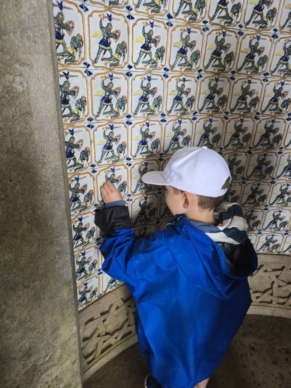 Noah touching patterned blue and white tiles at Pena Palace
