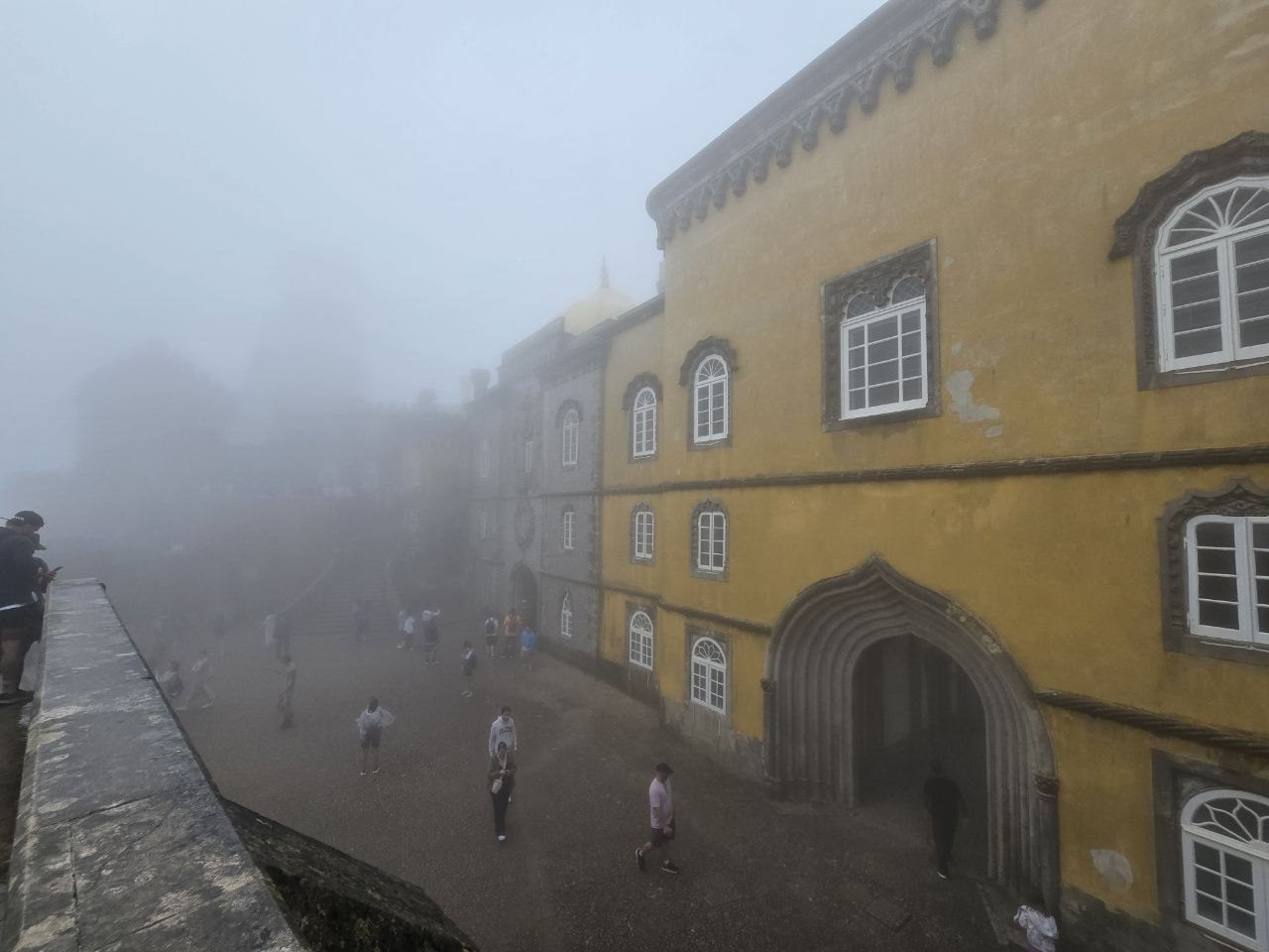 Yellow palace wall and courtyard fading into fog
