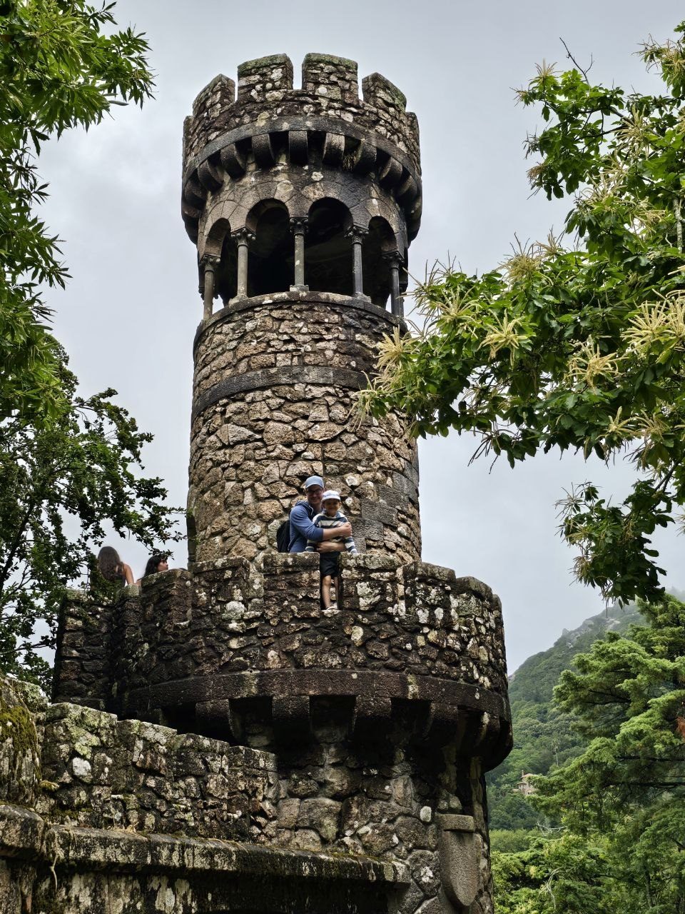 Round stone tower at Quinta da Regaleira surrounded by trees