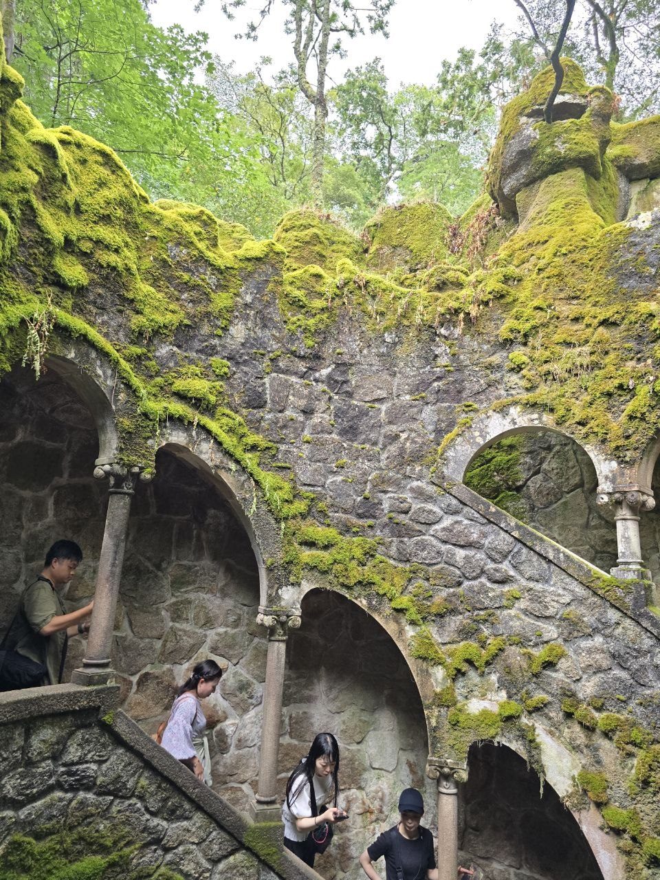 Mossy stone arches and stairs inside the Initiation Well