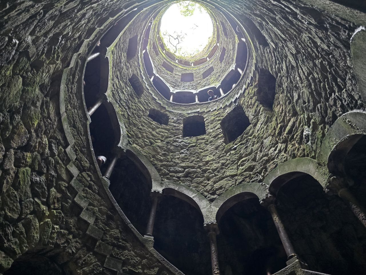 Upward view of spiral stone walls inside the Initiation Well