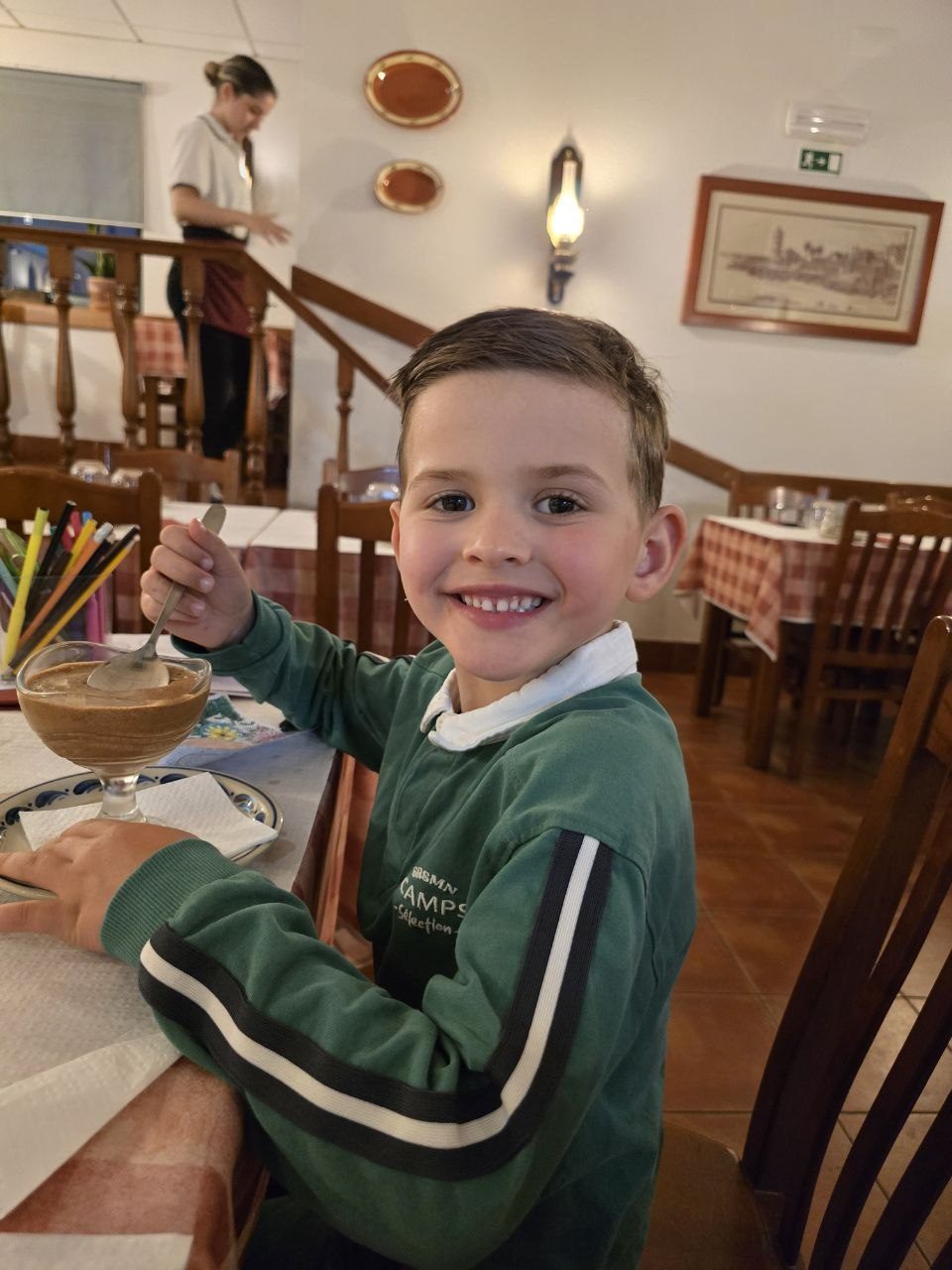 Noah smiling at a restaurant table in Cascais