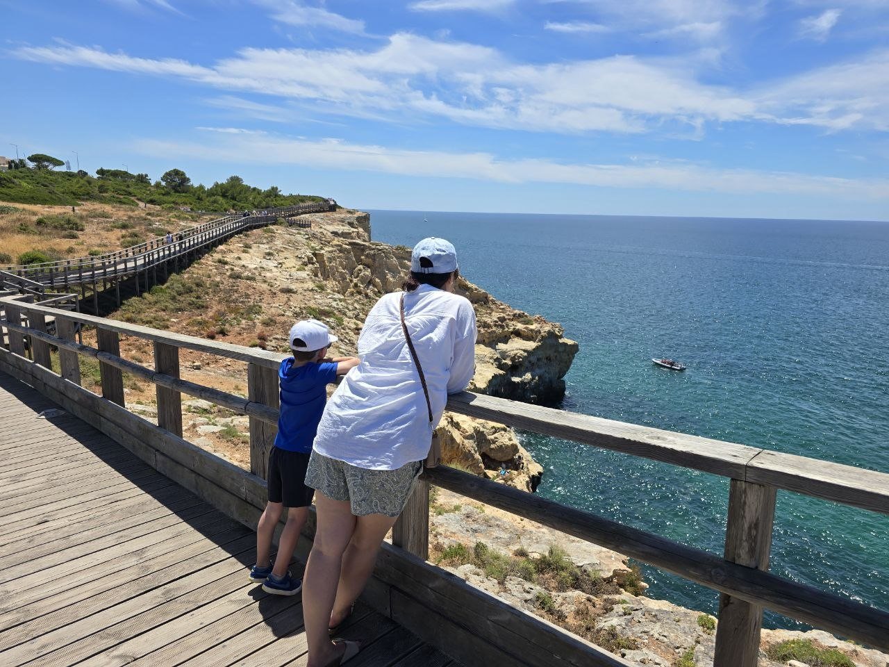 Dad and Noah looking over the Carvoeiro boardwalk railing toward the ocean
