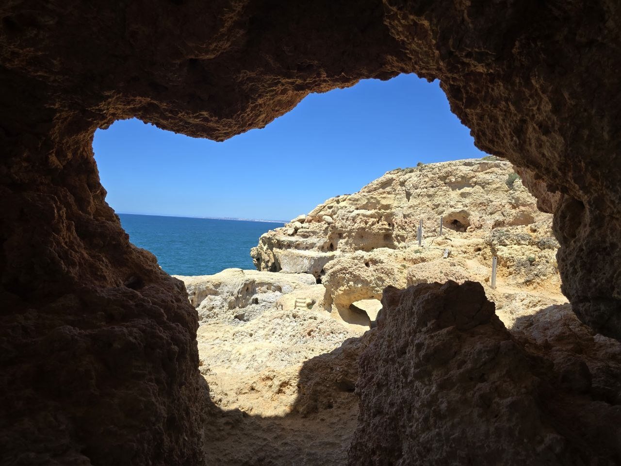 Ocean view framed by a natural cave opening at Algar Seco