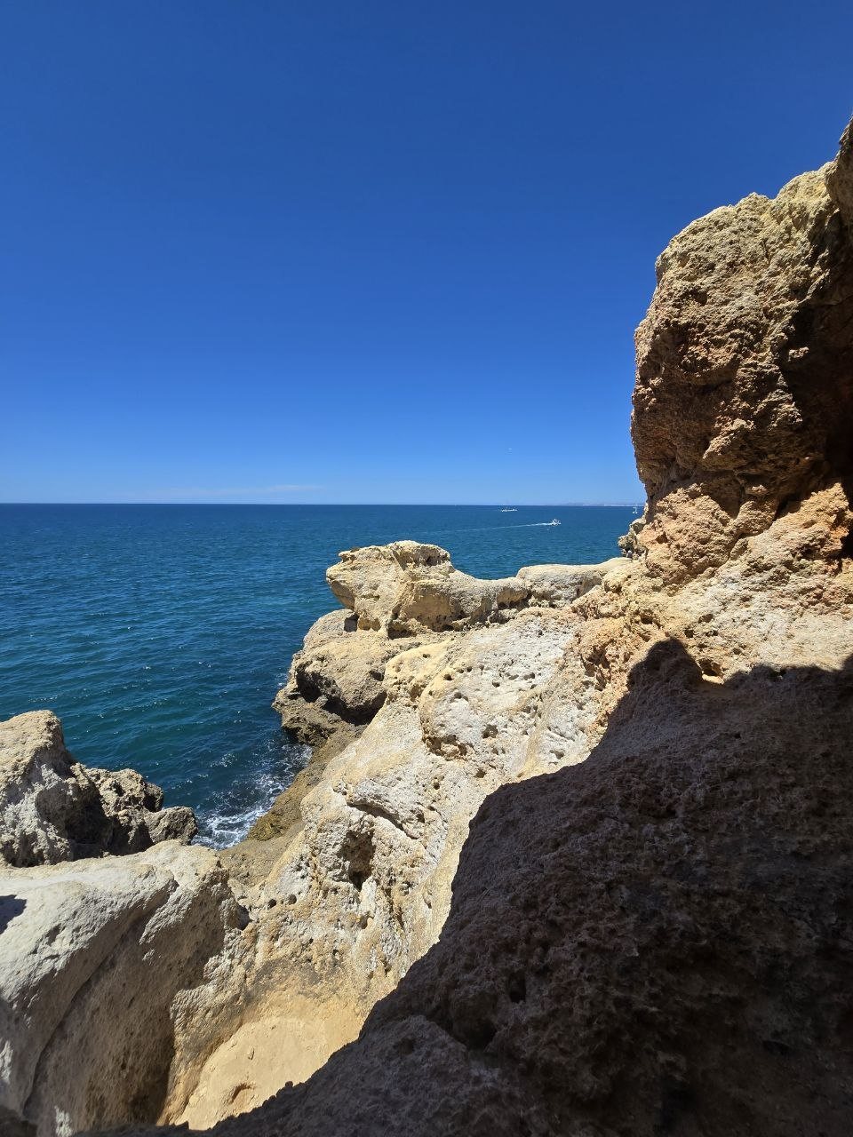 Turquoise water seen through a cut in the limestone cliffs