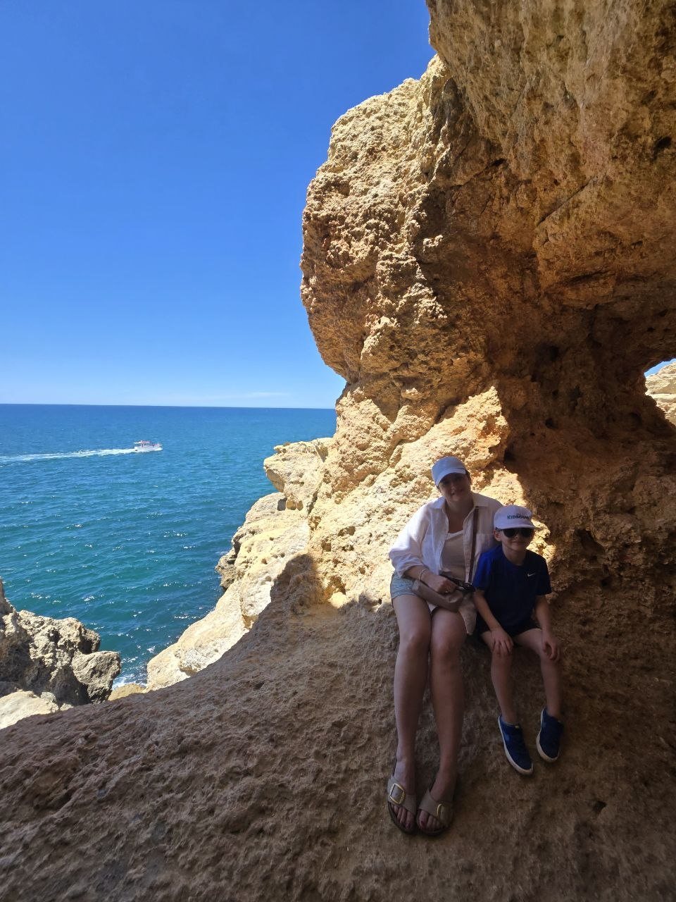 Family standing in shade below a limestone overhang