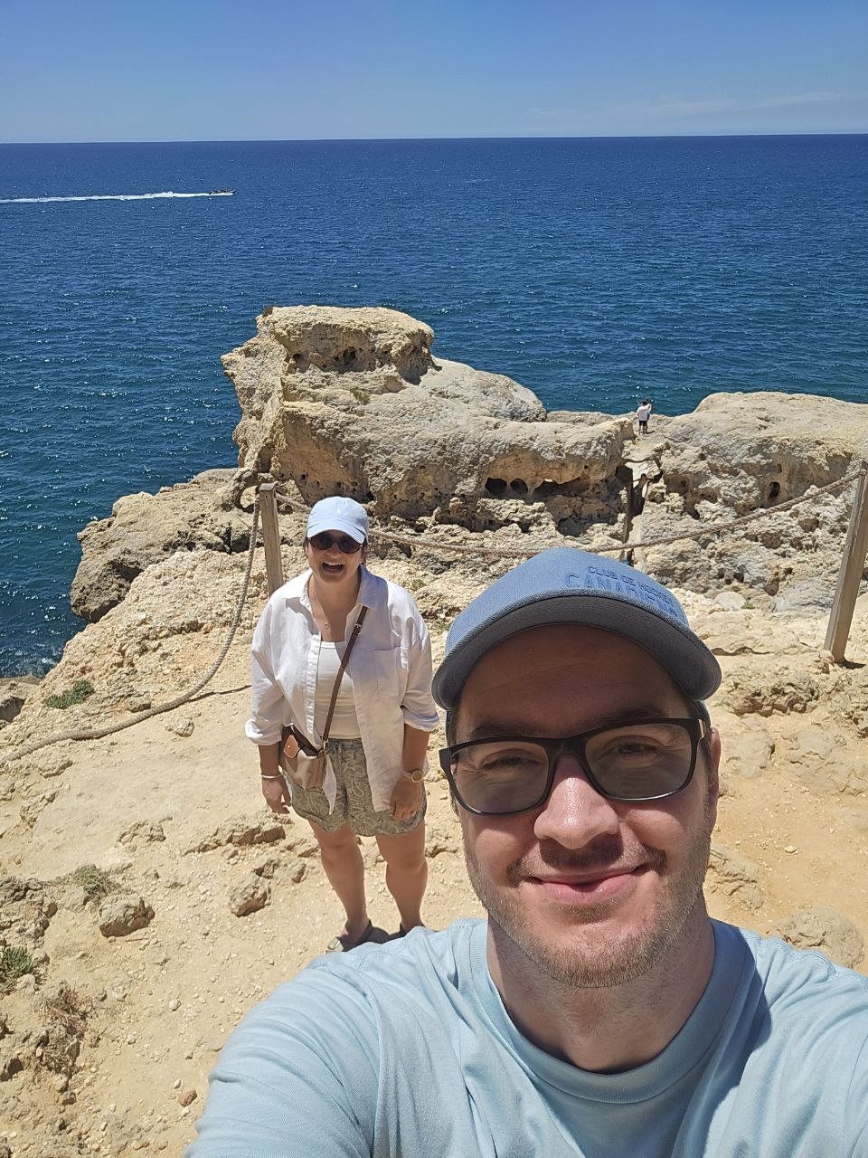 Family selfie above limestone rocks and blue ocean