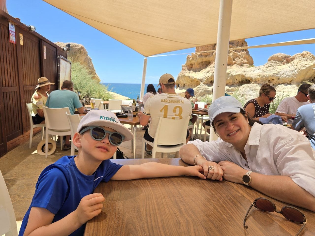 Noah and Catherine sitting at a shaded Boneca Bar table