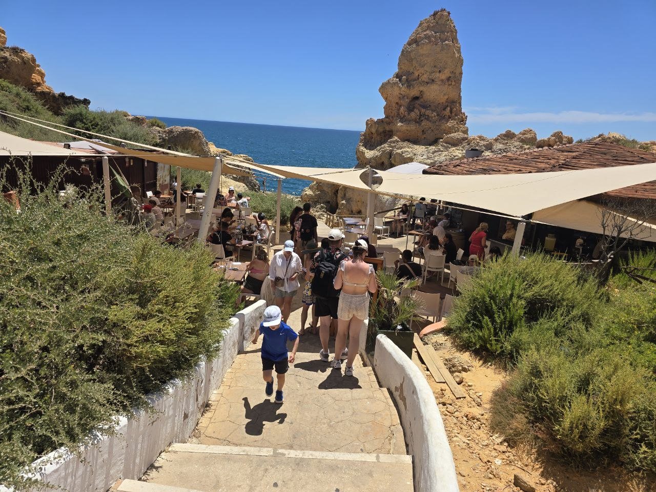 Path and stairs leading down to Boneca Bar between cliffs