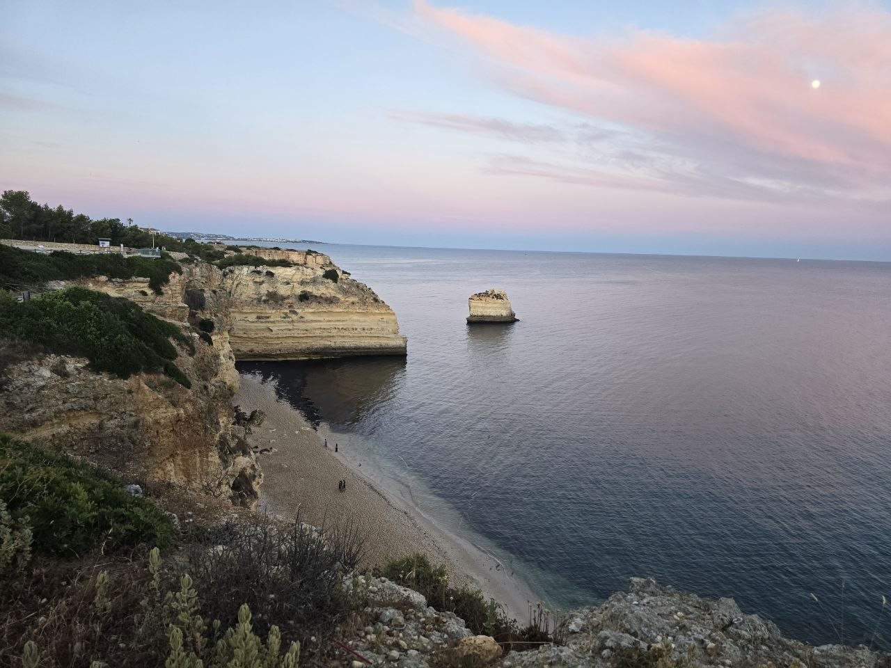 Marinha coastline under pink clouds with the moon in the sky