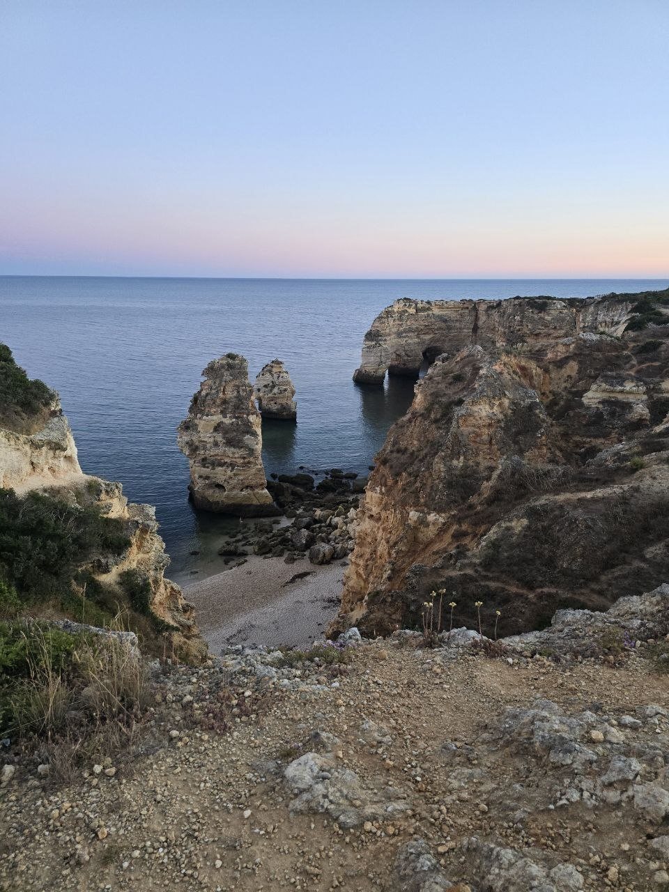 Twin limestone stacks below the Marinha cliffs at sunset