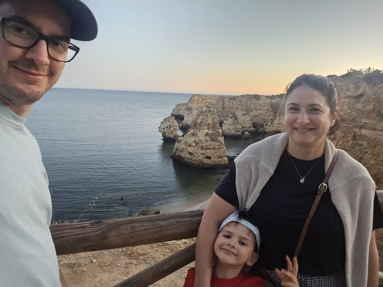 Family selfie at Marinha Beach sunset viewpoint with cliffs and ocean behind