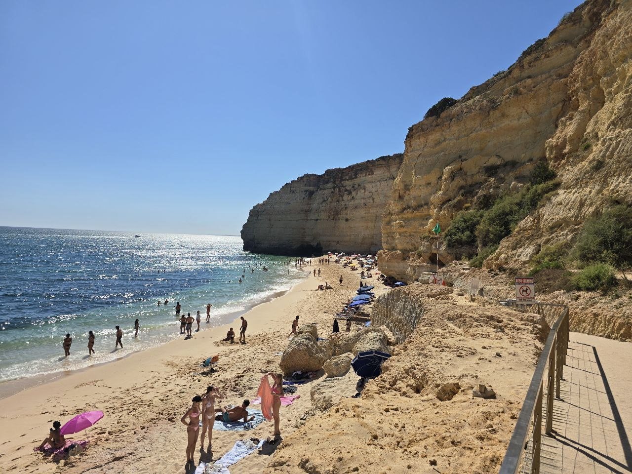 Overlook from the stairs above Vale de Centeanes Beach with swimmers and cliffs below