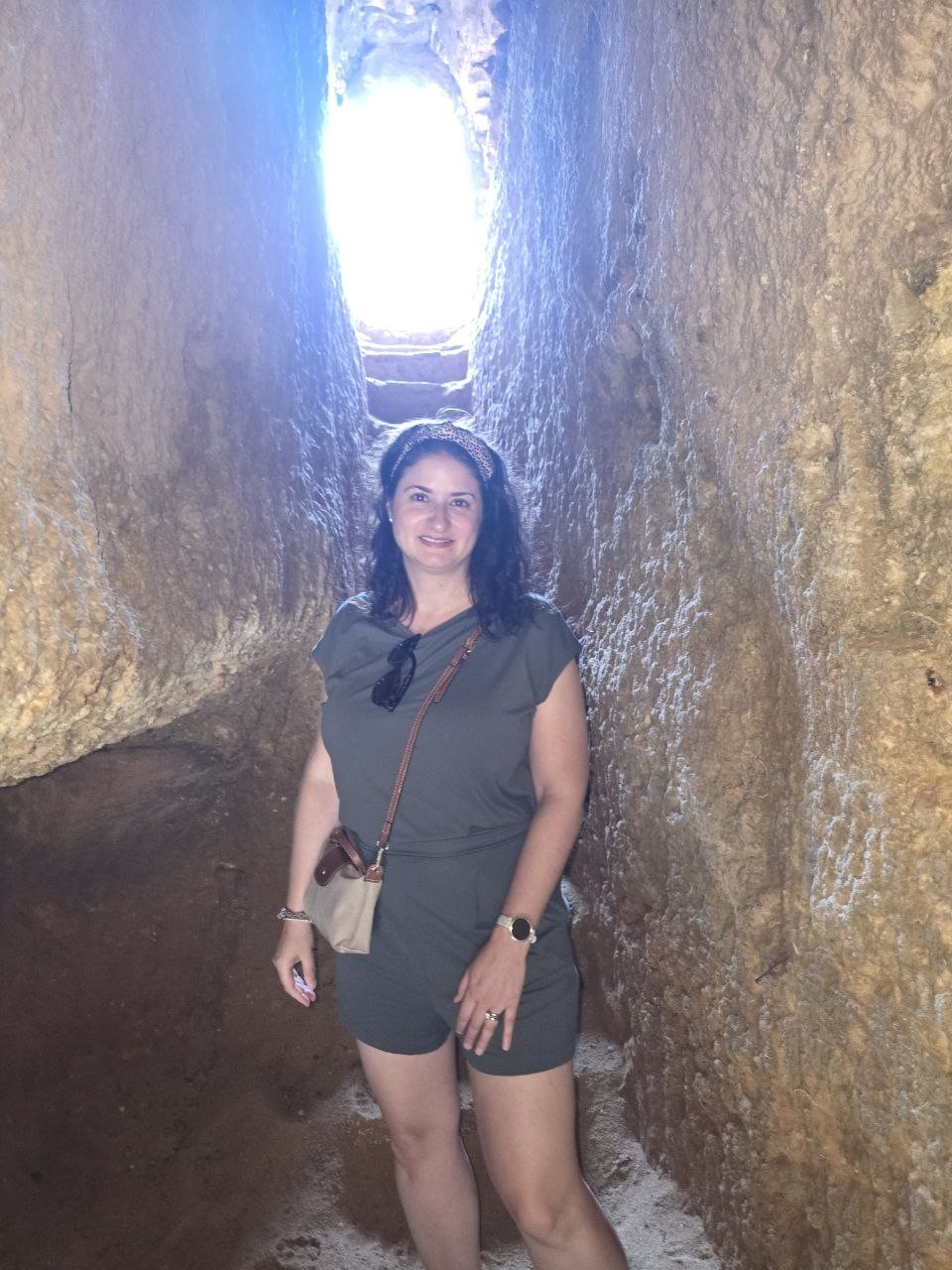 Catherine standing inside the carved rock tunnel at Praia do Carvalho