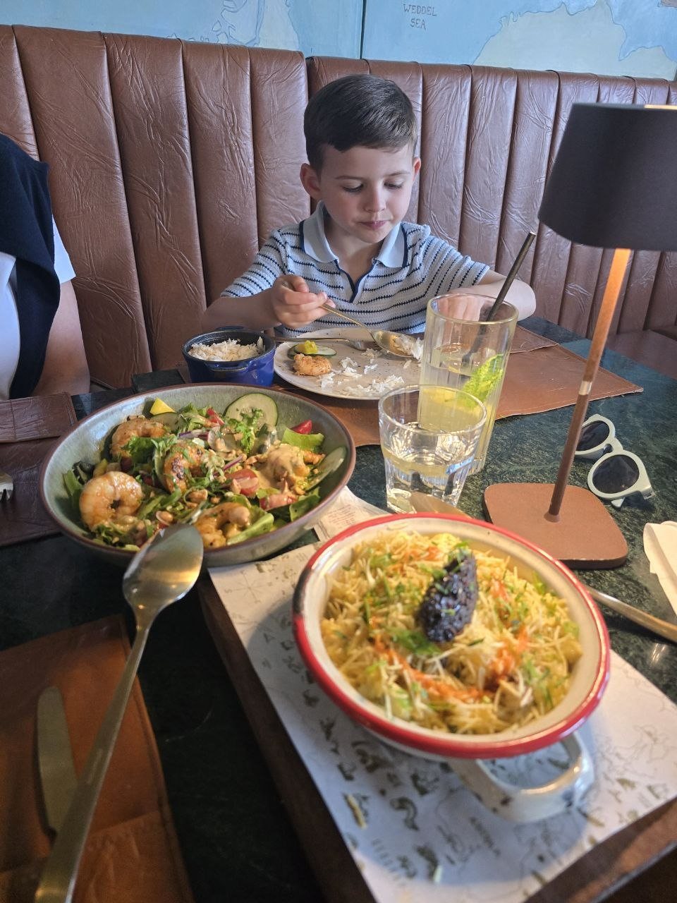 Rice, shrimp salad, and a baked dish on the table at Geographia