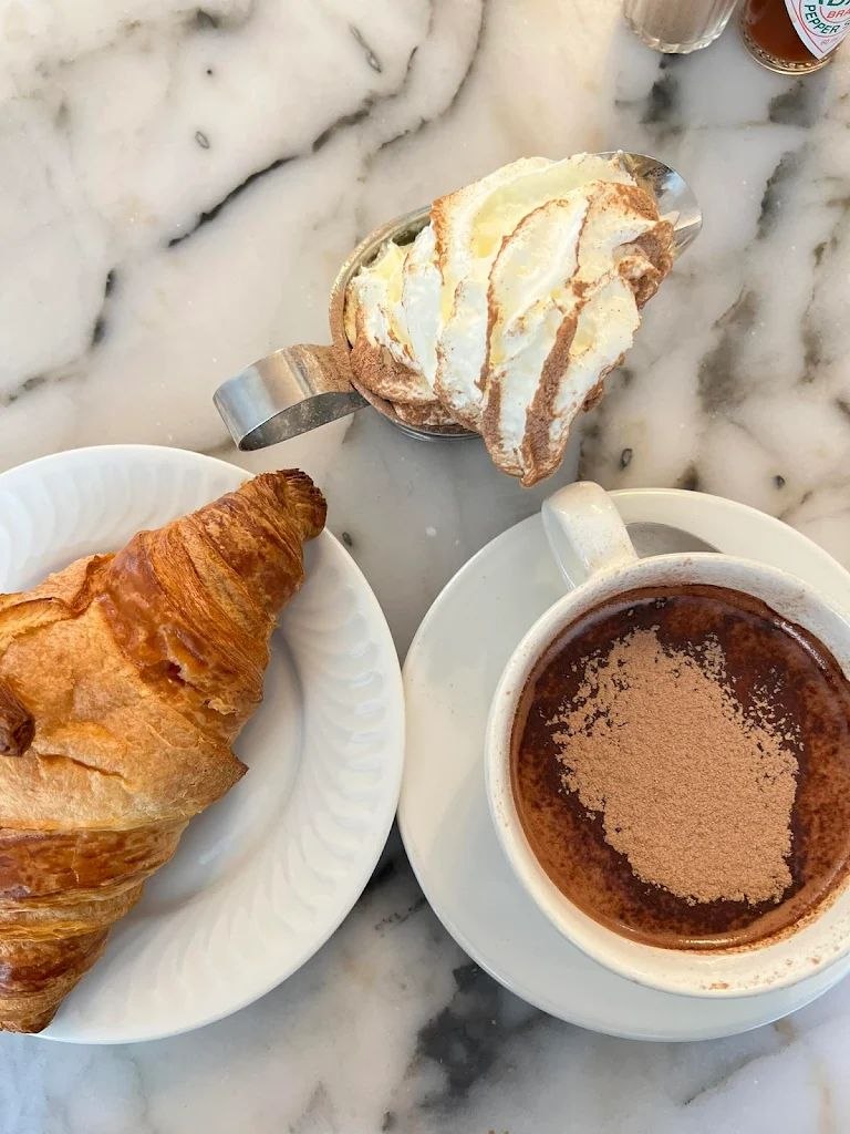 Breakfast Lovers Misericórdia photo 6: croissant, hot chocolate, and whipped cream on a marble table